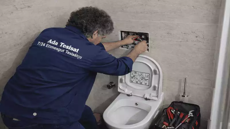 Etimesgut’ta klozet tamiri ve montajı yapan Ada Tesisat ustası rezervuar iç mekanizmasını onarıyor.