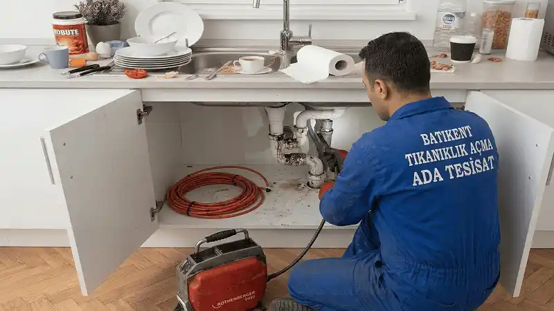 Batıkent'te mutfak lavabo tıkanıklığı açma işlemi yapan Ada Tesisat ustası, kırmızı robot cihaz ile kırmadan tıkalı pimaş boruya müdahale ederken.